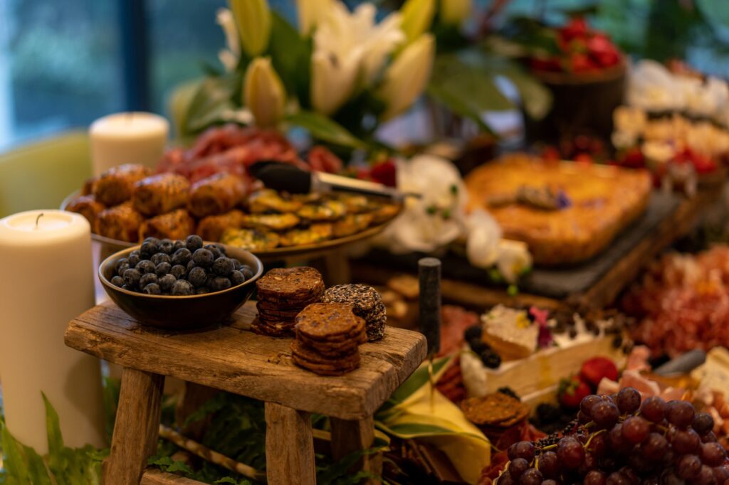 Antipasto platter with ham, prosciutto, salami, cheese, crackers and olives on a wooden table