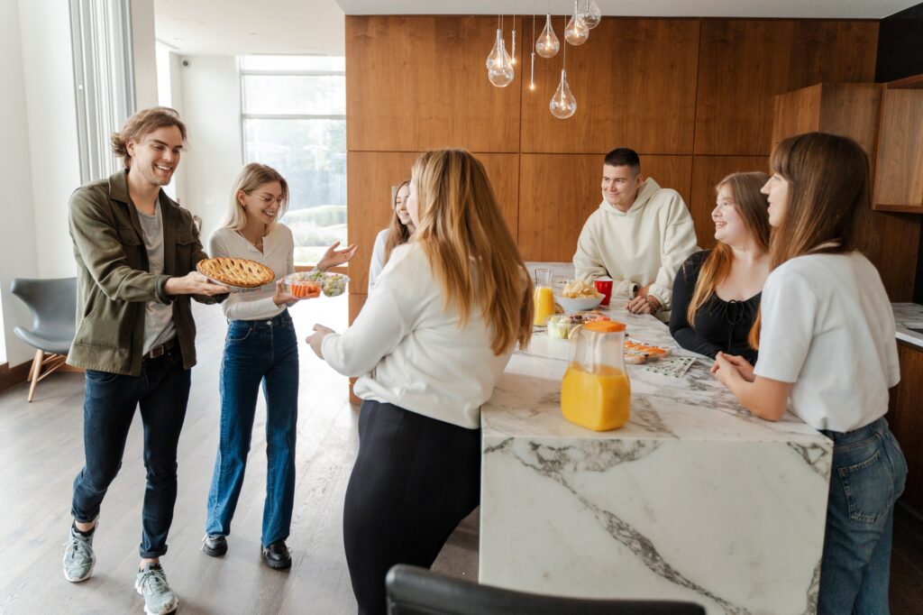 Positive friends celebrating birthday enjoying corporate party at home