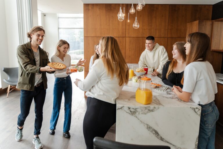 Positive friends celebrating birthday enjoying corporate party at home