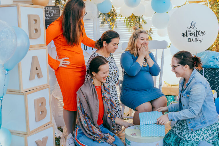 Women at a baby shower excited over a gift.