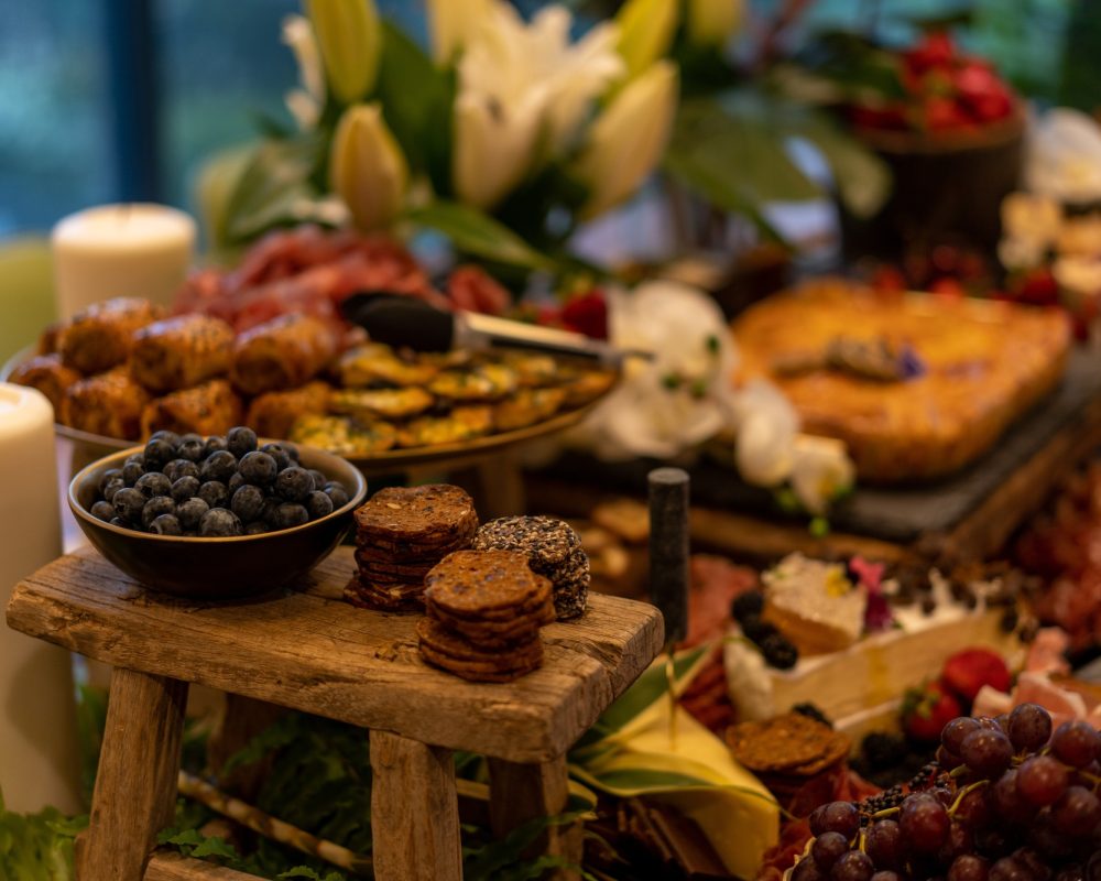 Antipasto platter with ham, prosciutto, salami, cheese, crackers and olives on a wooden table