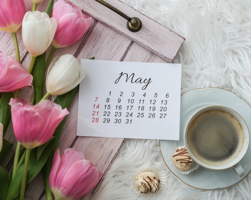 May calendar, tulips bouquet and a cup of coffee