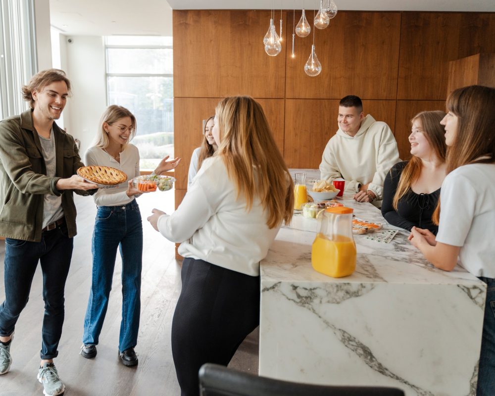 Positive friends celebrating birthday enjoying corporate party at home